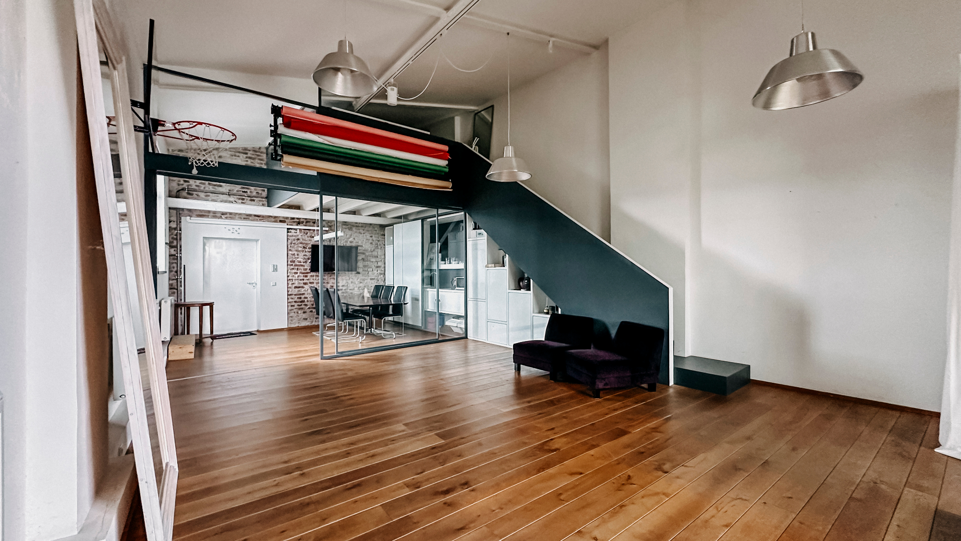 Offener Loftbereich mit Holzboden, Treppe und Hintergrundsystem